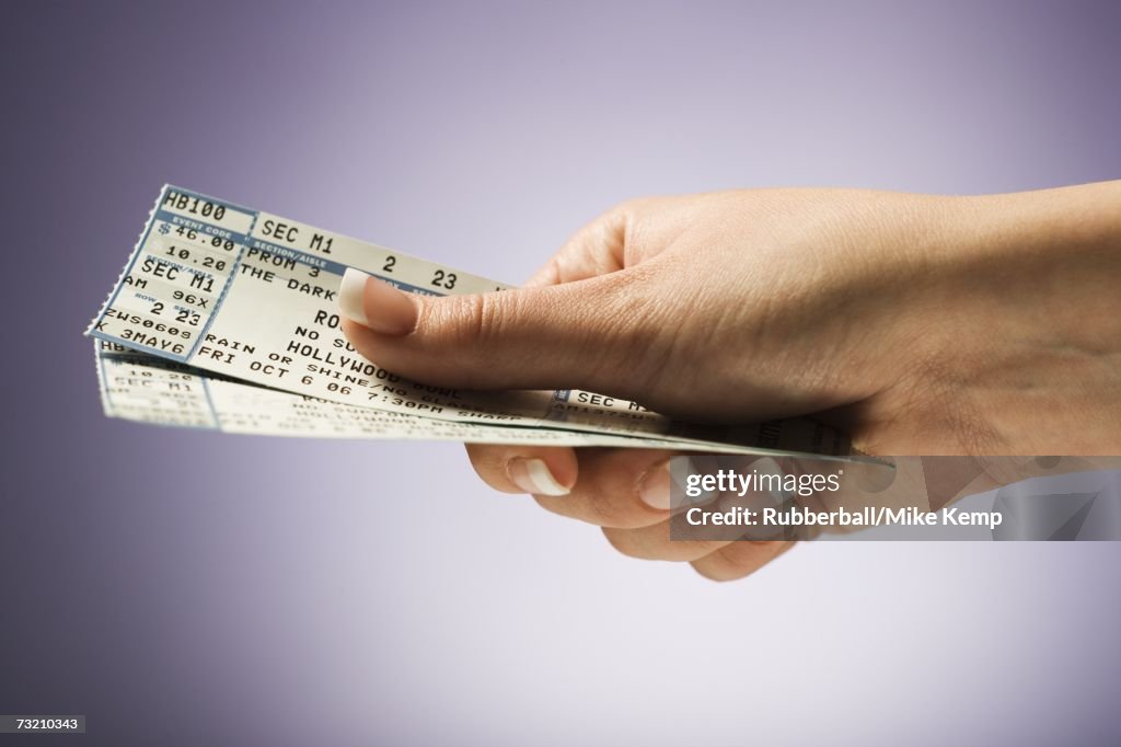 Woman holding concert tickets