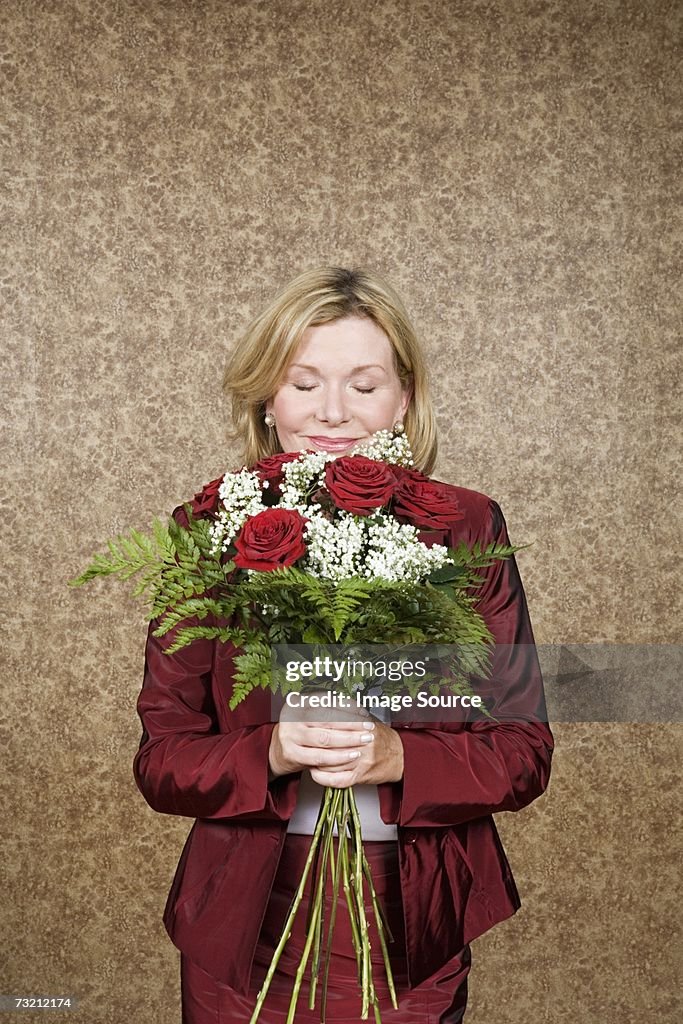 Woman smelling bouquet of flowers