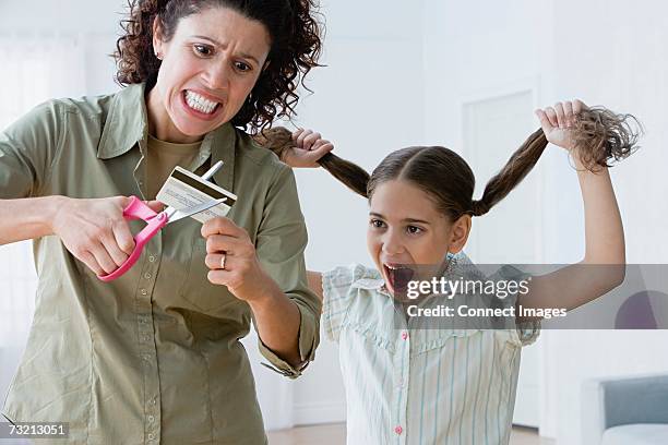 mother cutting up a credit card - child cutting card stock-fotos und bilder