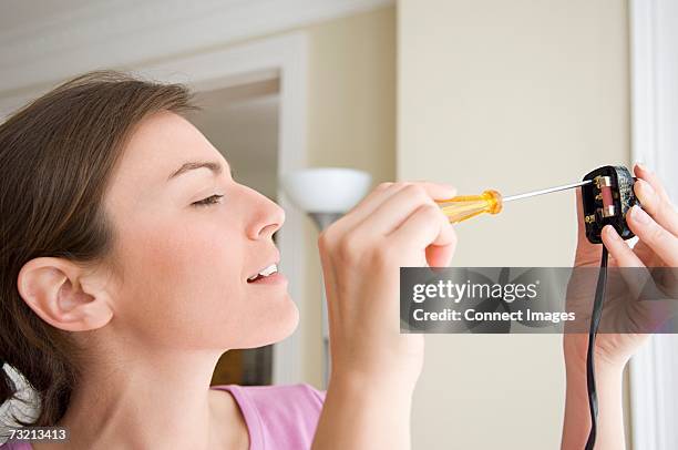 woman changing fuse on a plug - screwdriver stock pictures, royalty-free photos & images