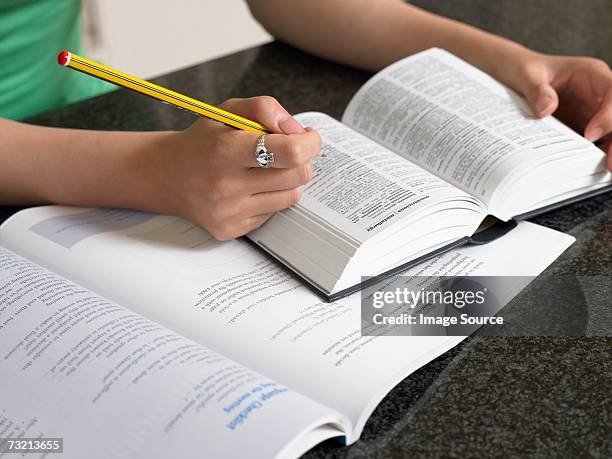 student with dictionary and textbook - definition stockfoto's en -beelden