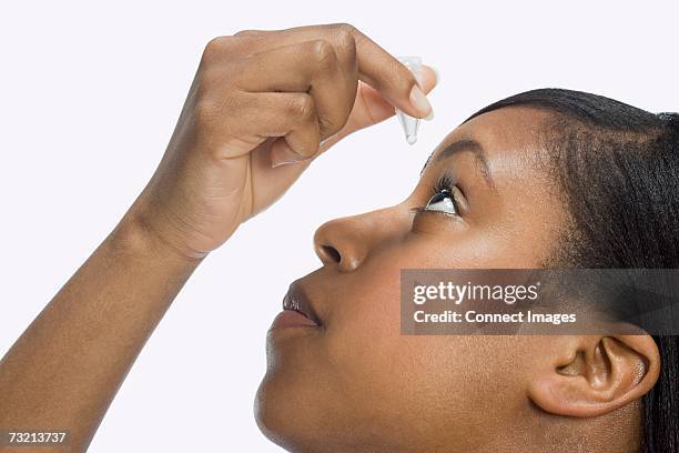 woman using eye drops - gotas para los ojos fotografías e imágenes de stock