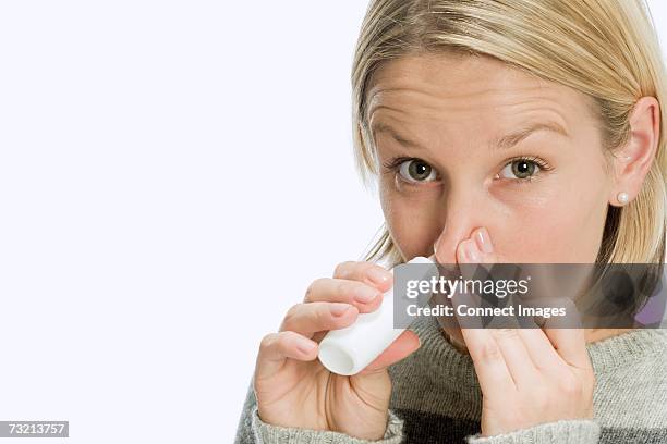 woman inhaling nasal spray - nasenspray stock-fotos und bilder