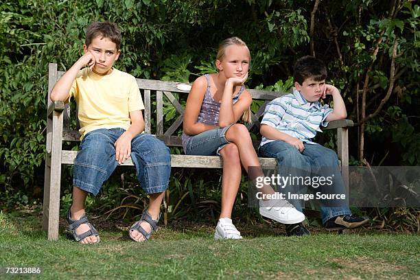 bored kids on a park bench - boredom stock pictures, royalty-free photos & images