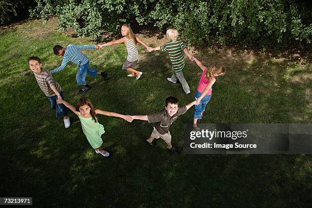 children holding hands in a circle - rodar - fotografias e filmes do acervo