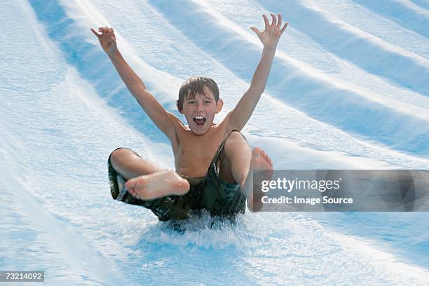 boy on a water slide - water slide bildbanksfoton och bilder