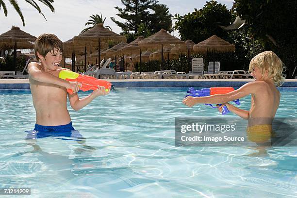 boys fighting with water pistols - toy gun stock pictures, royalty-free photos & images