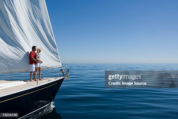 couple standing on a ships bow - male sailing stockfoto's en -beelden