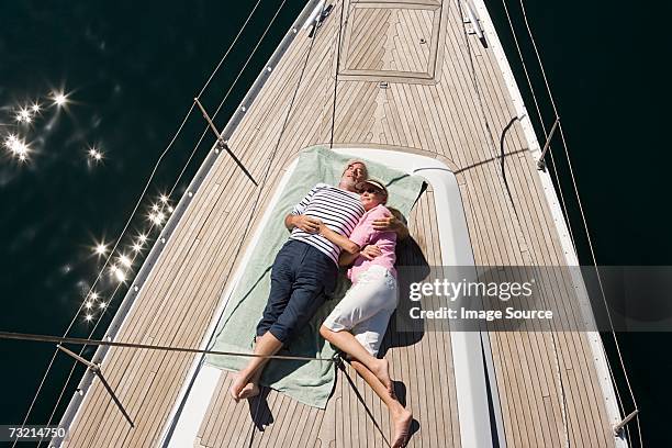 couple endormi sur le pont du bateau à voile - bateau à voile en famille photos et images de collection