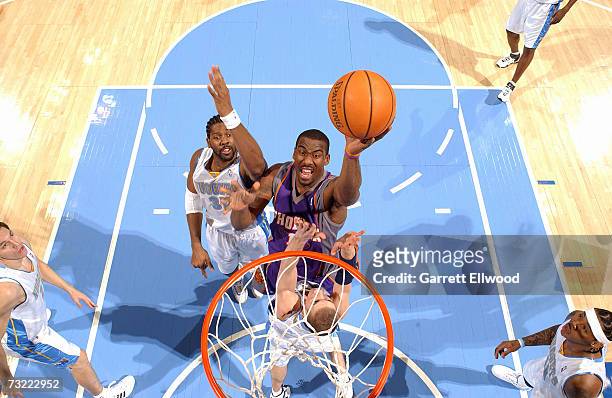 Amare Stoudemire of the Phoenix Suns goes to the basket against Steve Blake and Nene of the Denver Nuggets on February 5, 2007 at the Pepsi Center in...
