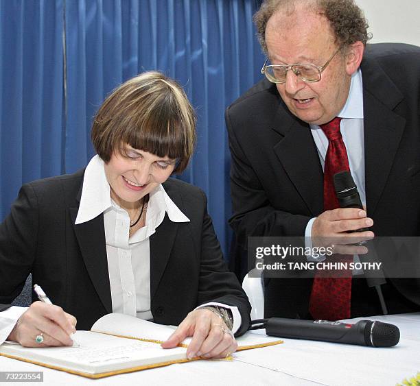 Swiss President Micheline Calmy-Rey signs her name as Doctor Beat Richner of the Kantha Bopha Children's Hospital looks on during her visit to the...