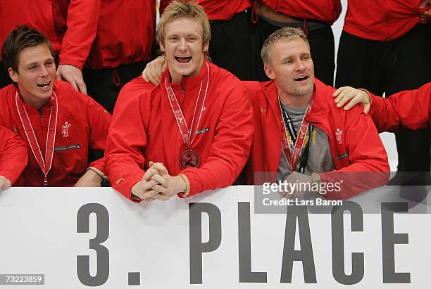 Soeren Stryger, Lasse Boesen and goalkeeper Peter Henriksen celebrate their third place after the IHF World Championship game between France and...