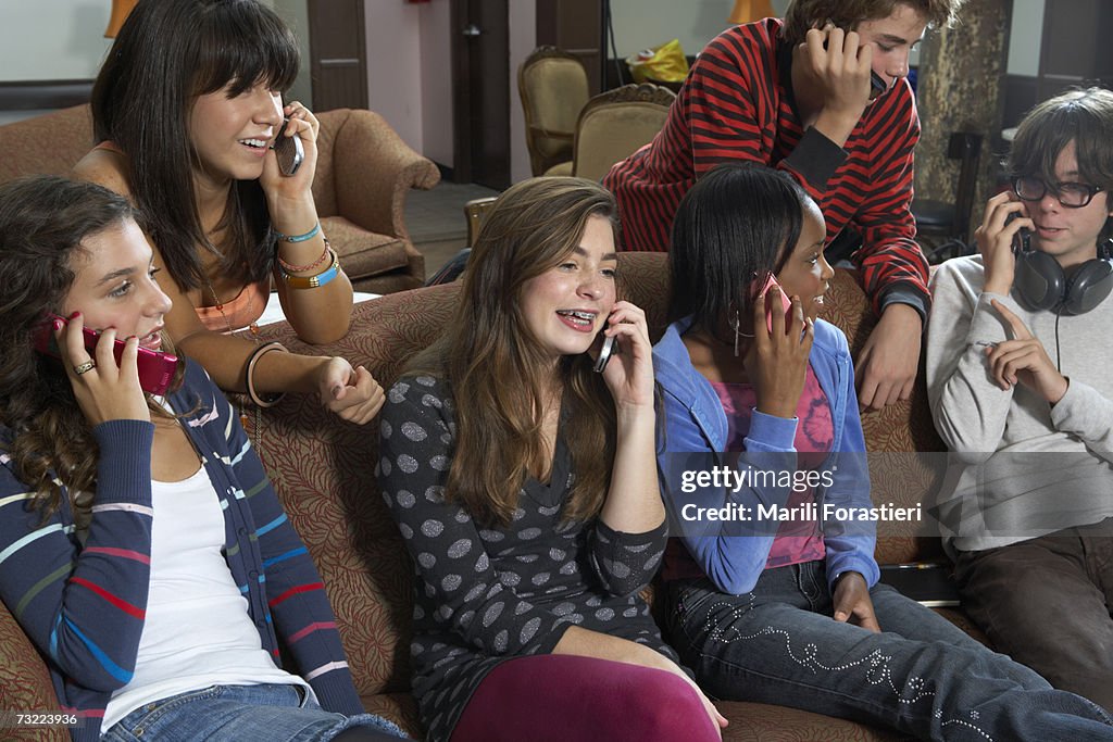 Group of people sitting in caf?, using mobile phone. smiling, close-up