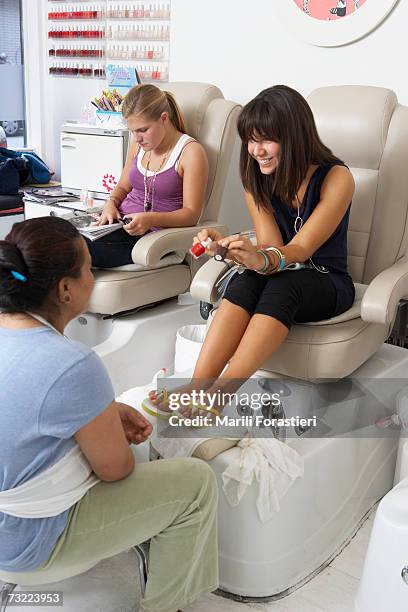 young woman in beauty salon selecting nail polish - pedicure stockfoto's en -beelden