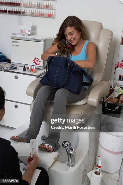 young woman on mobile phone giving money to beautician, smiling - purses and body care stock pictures, royalty-free photos & images