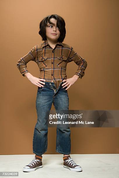 boy (8-9) wearing short jeans, hand on hips - zu klein stock-fotos und bilder