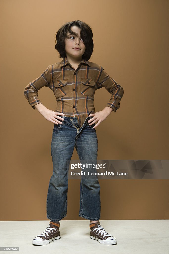 Boy (8-9) wearing short jeans, hand on hips