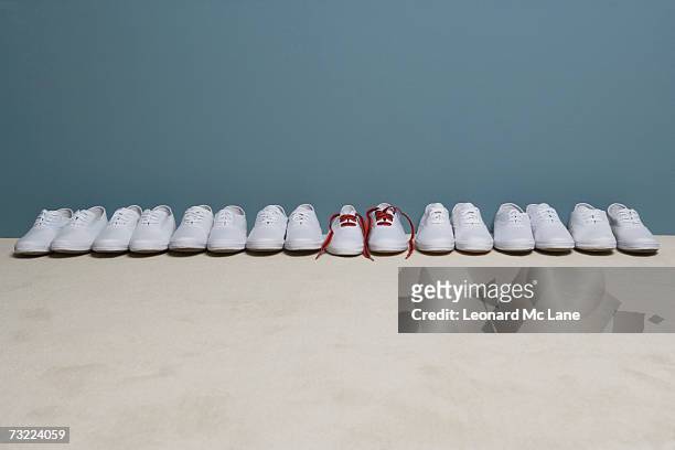 pair of shoes in row against wall - shoes in a row stock pictures, royalty-free photos & images