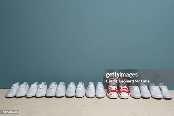 pair of shoes in row against wall - conjunto fotografías e imágenes de stock