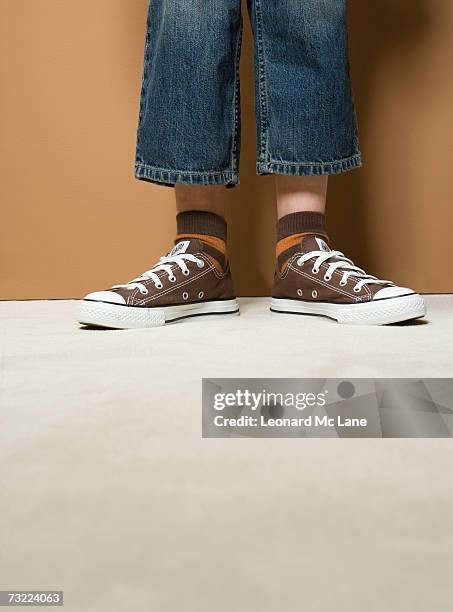 boy (8-9) wearing short jeans, low section - boy jeans stockfoto's en -beelden