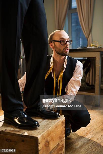 tailor adjusting man's trousers, close-up - tailor pants stock pictures, royalty-free photos & images