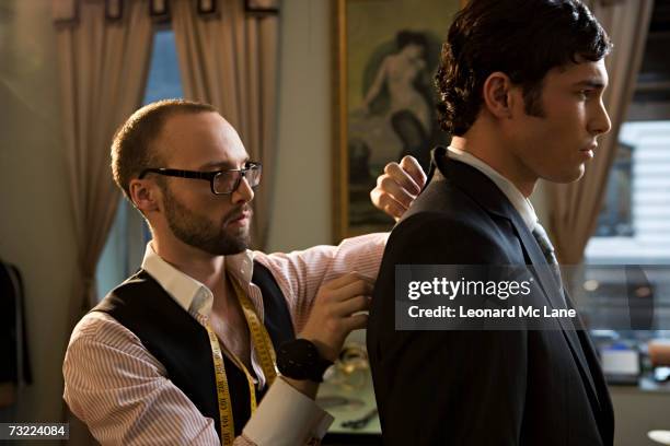 tailor adjusting suit on man, close-up - sastre fotografías e imágenes de stock