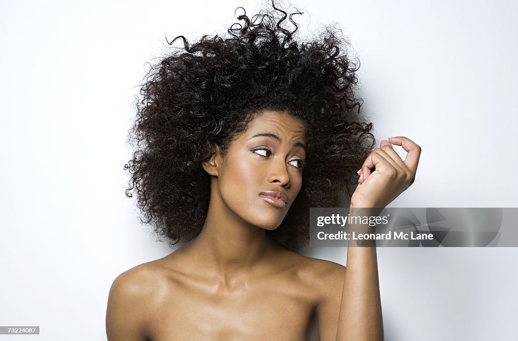 Jeune femme regardant dans son cheveux, gros plan