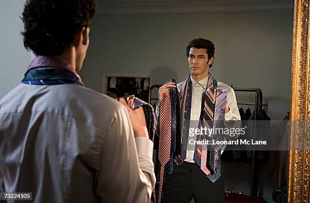 man trying on tie, standing in front of mirror - tie bildbanksfoton och bilder