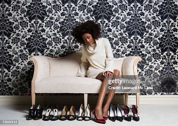 woman sitting on sofa, trying on shoes - women trying on shoes 個照片及圖片檔