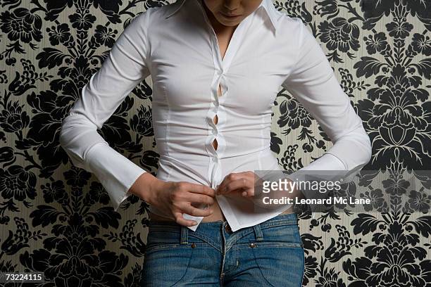 woman wearing fitting shirt, mid section - too small stockfoto's en -beelden