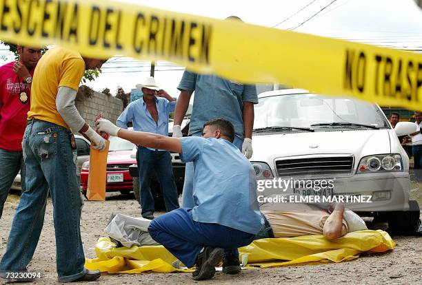 Tegucigalpa, HONDURAS: Empleados del Ministerio Publico de Honduras trabajan en el cuerpo de un empresario nicaraguense acribillado por supuestos...