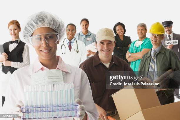 studio shot of men and woman in various occupational uniforms - hard hat white background stock pictures, royalty-free photos & images