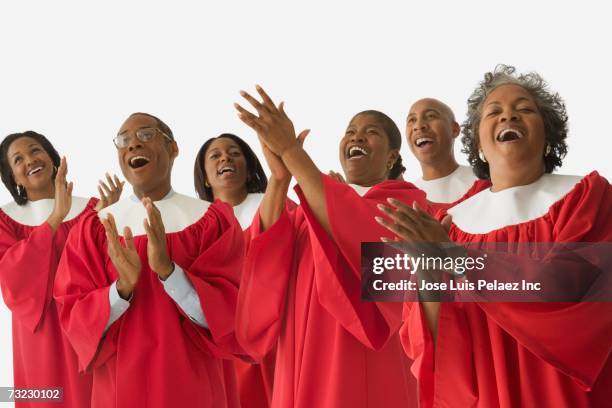 studio shot of african men and women in choir gowns singing - coro fotografías e imágenes de stock