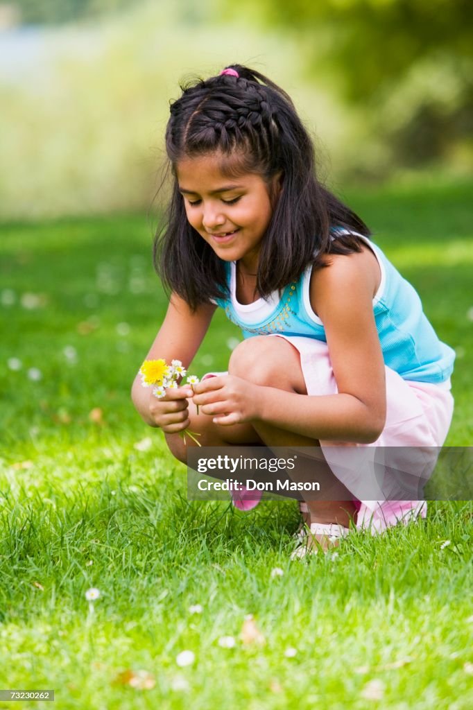 Hispanic girl picking flowers