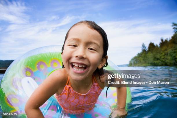 close up of young asian girl smiling in inner tube in water - standing water ストックフォトと画像