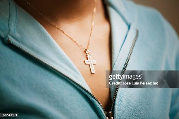 close up of cross necklace on woman - a cross necklace stock-fotos und bilder