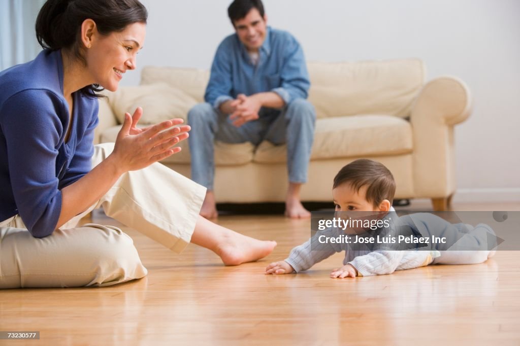 Mother clapping with baby on floor