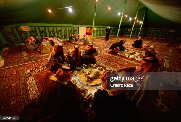 Prince Abdullah Bin Saad Bin Jilani Al Saoud serves a traditional meal of mutton to guests who arrive for a "majlis" under his tent at the heart of...