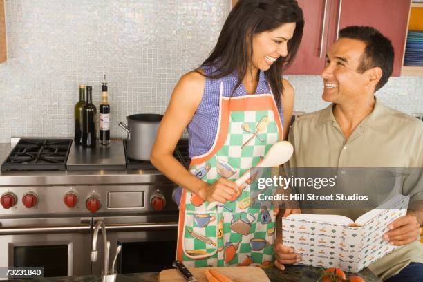 hispanic couple cooking in kitchen - arab couple stock pictures, royalty-free photos & images