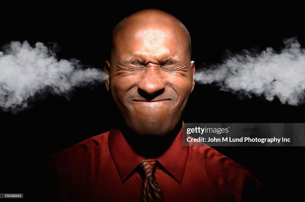 African man with eyes closed and steam coming from ears