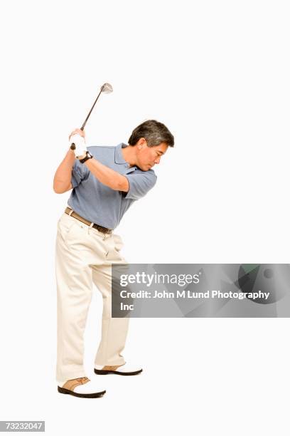 studio shot of senior asian man playing golf - senior golf swing stock pictures, royalty-free photos & images