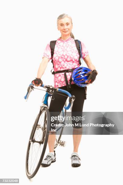 studio shot of senior woman with bicycle and helmet - bicycle isolated stockfoto's en -beelden