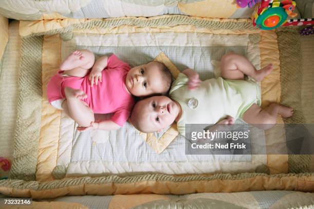 high angle view of two babies laying on blanket - twin babies stockfoto's en -beelden