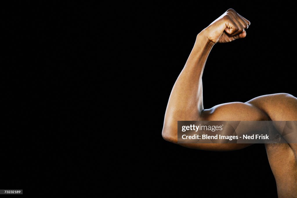 Studio shot of African man flexing biceps