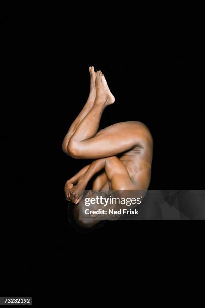 studio shot of nude african man in fetal position - fetal position fotografías e imágenes de stock