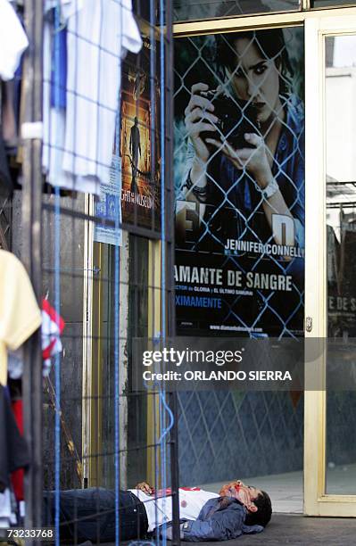 El cadaver de uno de dos jovenes comerciantes asesinados permanece en la acera del cine Lux en la sexta avenida o "Calle del Comercio", del centro...