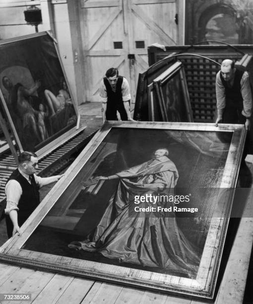 Attendants take 'Cardinal Richelieu' by Philippe de Champaigne out of storage for routine inspection in an underground facility at Manod Quarry,...