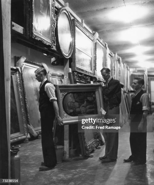 Paintings are taken out of storage and hung up in the main hall for routine inspection at an underground facility at Manod Quarry, north Wales, where...