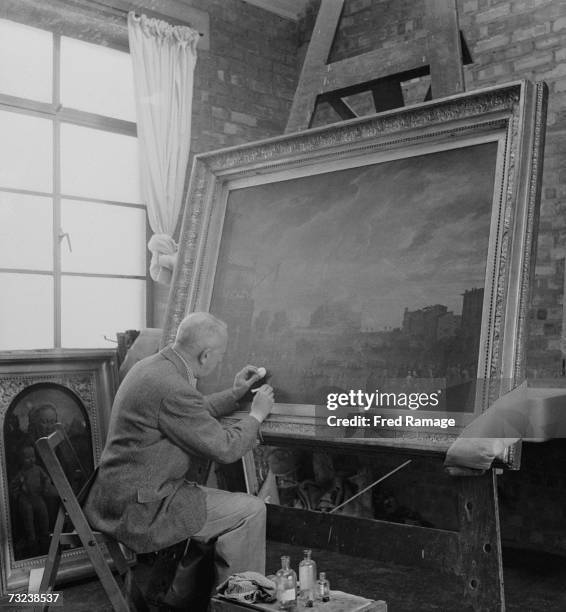 Art restorer W.A. Holder working on 'A Sporting Contest on the Tiber at Rome' by Joseph Vernet in a studio at Manod Quarry, north Wales, where...