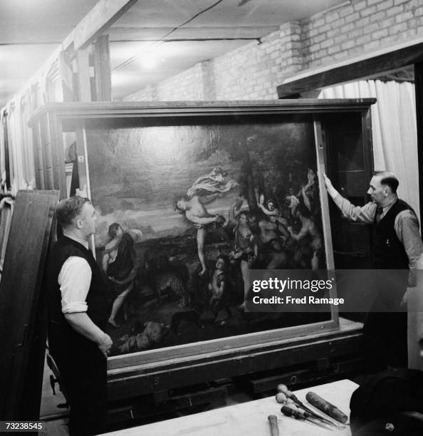 Attendants take a painting out of storage for routine inspection in a subterranean chamber at Manod Quarry, north Wales, where paintings from the...